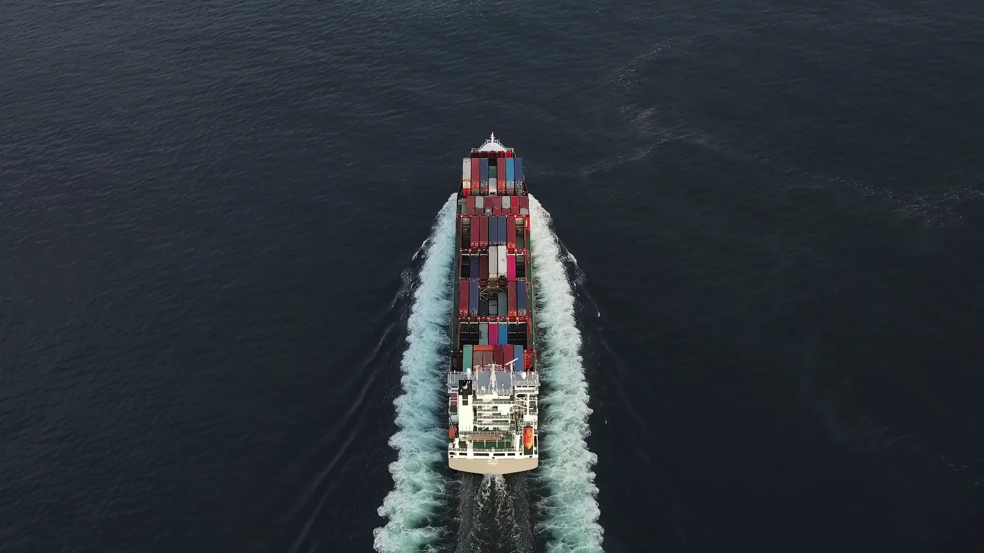A container ship under way at sea, seen from directly above.