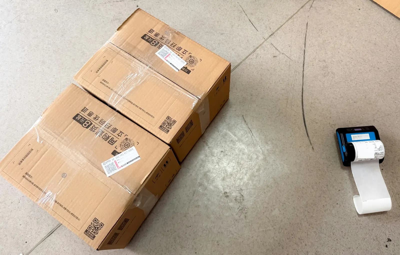 Shipping boxes beside a small label printer.