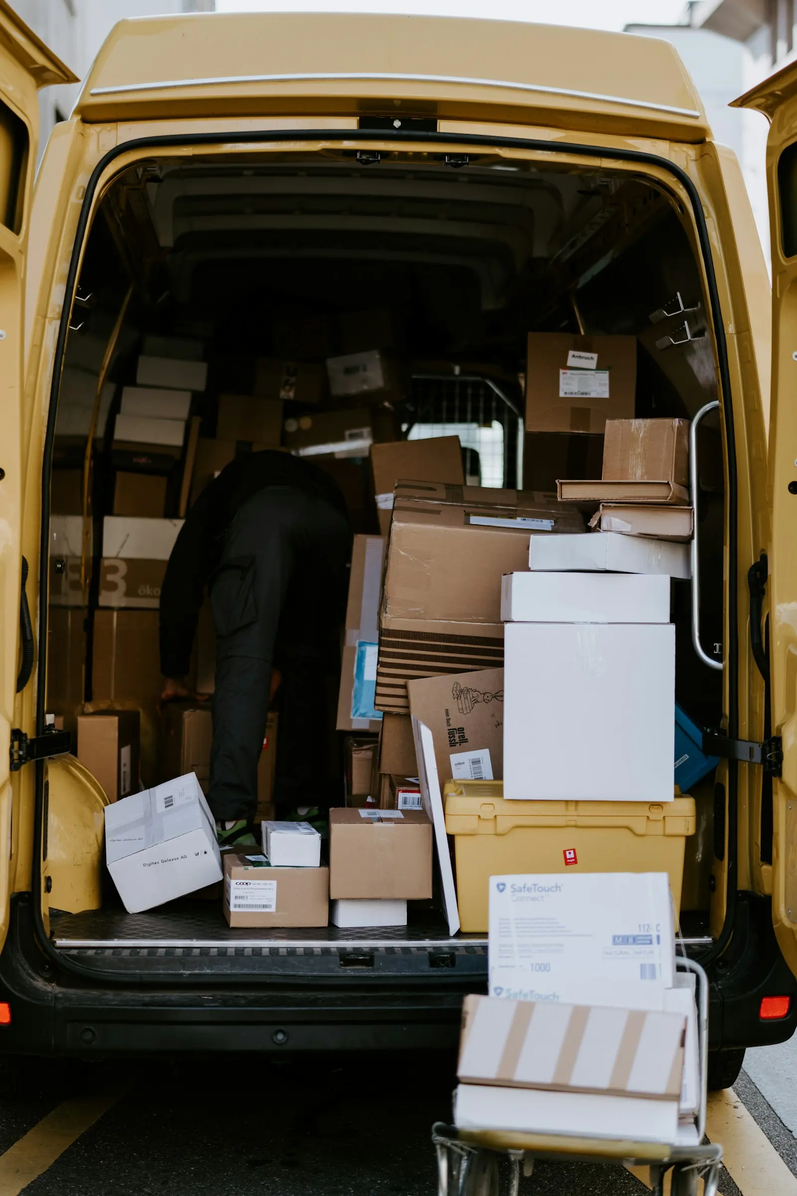 Boxes being loaded into the back of a delivery van.